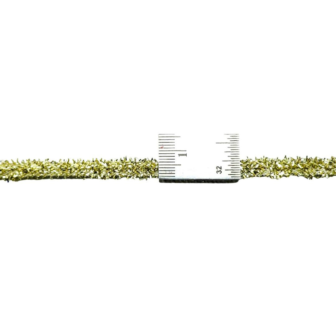 Gold chain with a ruler for scale on a white background